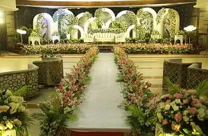 Elegant wedding reception stage decoration with floral backdrop and lighting setup